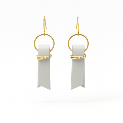 A pair of light gray leather ribbon earrings accented with gold-plated wire and rings on a white background.
