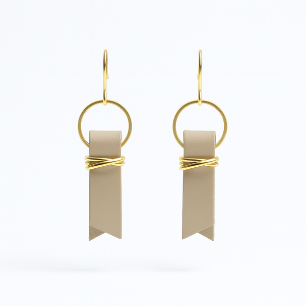 Beige leather ribbon earrings accented with gold-plated wire and rings on  a white background.